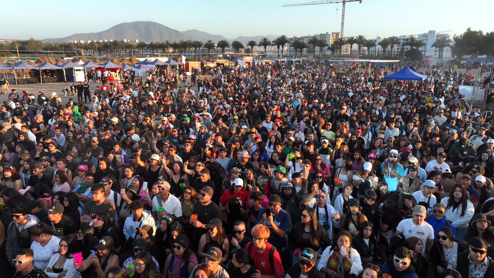 Evento masivo al atardecer con puestos de venta